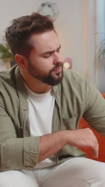 Baş ağrısından muzdarip bir adam su, sağlık ve tedavi ile birlikte oturma odasında tedavi, bakım ve rahatlama alıyor. Erkek hasta ilaç, anksiyete ya da su, ilaç ya da hastalığın tedavisi.