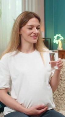 Evde orta yaşlı hamile bir kadın bir bardak su içiyor göbeğine dokunan ellerle su ihtiyacını gideriyor. Kanepede oturan beyaz bir kız annelere her gün sağlıklı kalmalarını söyleyen bir alışkanlık sergiliyor..