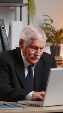 Dizüstü bilgisayar ağı üzerinde çalışan üst düzey mutlu Kafkasyalı işadamı ani zafer, galibiyet, gol başarısı, iyi kariyer haberleri karşısında şok oldu. Heyecanlı serbest çalışan büyükbaba iş yerinde yumruklarını sıkıyor.