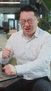 İş sırasında ofis lobisindeki dizüstü bilgisayarda aşırı yemek yiyen hasta Çinli iş adamı hayal kırıklığına uğradı. Acı çeken, karın ağrısı, kramp ve zehirlenme geçiren hasta bir menajer.