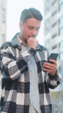 Şehir merkezinde online şok yaşayan erkek turist kazanan cep telefonu kullanan beyaz adam zafer başarısını kutlamak için akıllı telefon bahsini kazandı. Şehir sokağında duran adam.