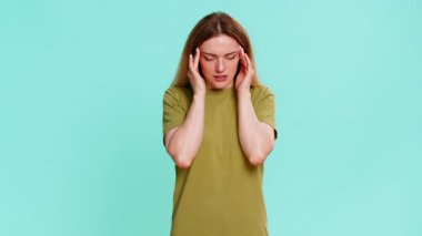 Orta yaşlı bir kadın kafasını tutuyor ve şakaklarına rahatsızlık veriyor. Migren veya baş ağrısı belirtileri gösteriyor. Mavi arka planda izole edilmiş bir kız stres, gerilim ve fiziksel rahatsızlık gösterir.