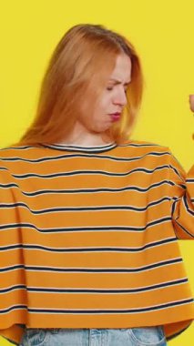 Duymak istemiyorum, dinle. Sinirli, sinirli, genç, sarışın bir kadın. Kulakları tıkayarak hayır diyor. Tavsiyeden kaçınıyor, rahatsız edici sesleri görmezden geliyor. Sarı arkaplanda izole edilmiş kız