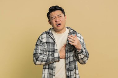 Stresli, orta yaşlı, Asyalı orta yaşlı bir adam kalp krizi geçirerek, kalp krizi geçirerek, kalp krizi geçirerek, kötü bir hastalık belirtisi göstererek gerilimden muzdarip..