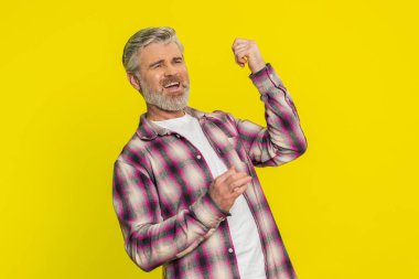 Olgun bir adam görünmez hayali gitarla çalar, enerjik bir şekilde rock-n-roll yapar, müziğin ritminden zevk alır. Sarı arka planda orta yaşlı bir adam dans ederken mutlu hissediyor.