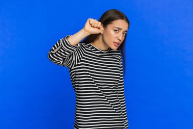 Kim var orada? Tık-tık. Kafası karışmış, kapıyı çalan beyaz bir kadın evde kimin utandığını soruyor. Hiçbir şeyden habersiz ve emin değil. Mavi arka planda izole edilmiş genç bir kız.