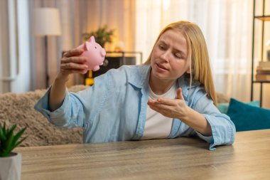 Hüsrana uğramış genç bir kadın evde para kazanmaya çalışıyor, üzgün yüzüyle domuz kumbarasını soyuyor. Masada oturan beyaz kız iflasın farkına varıyor ve maddi yetersizliğini gösteriyor. Gün batımı ışığı