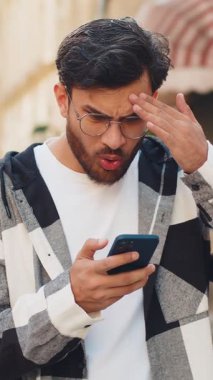 Hintli genç adam akıllı telefon daktilo kullanıyor. Ani piyango sonuçlarını kaybediyor. Kötü haber, servet kaybı, başarısızlık. Şehir caddesinde duran turist. Kasaba yaşam tarzları.