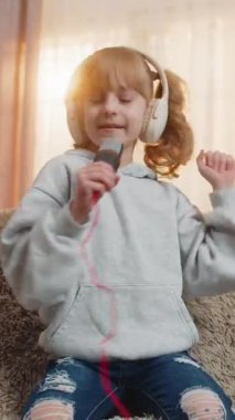 Genç kız evde dans ederken kulaklık takıyor, oyuncak mikrofon tutarken en sevdiği şarkıyı mırıldanıyor. Kanepede el sallayan sarışın çocuk, büyük bir performans ve kişisel mini konser hayal ediyor.