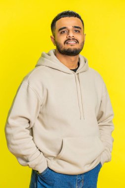 Neşeli, sevimli, mutlu, mutlu, Hintli bir adam gülümseyen, mutlu, mutlu bir yüz ifadesiyle kameraya bakan, dinlenme hayalleri kuran, rahatlatıcı, mutlu bir haber. Sarı stüdyo arka planında izole edilmiş Arap Hindu adam.