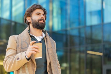 Mutlu Hintli genç adam sabah kahvesinin tadını çıkarıyor sıcak içecek ve dışarıda gülümsüyor. Dinleniyorum, ara veriyorum. Lübnanlı adam şehir merkezinde yürüyüp kahve içiyor. Dışarıdaki kasaba yaşam tarzları