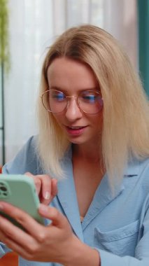 Aman Tanrım. Vay canına. Heyecanlı mutlu, neşeli, serbest çalışan genç bir kadın akıllı telefon kullanarak ekranda kutlama yaparak iyi haber kazanıyor. Rüzgarlı saçlı iş kadını telefonda konuşuyor..