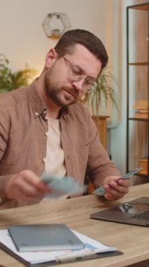 Planlama bütçesi. Zengin mutlu işadamı Ukrayna 'nın Hryvnias UAH nakitini hesaplamak için evde dizüstü bilgisayar kullanıyor. Planlanan tatil hediyeleri için maaş kazancından memnun olan adam..