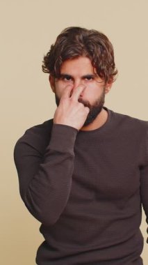 Gözüm üzerinde. Kendine güveni tam genç Hintli adam, kameraya ve gözlerine bakıyor, jest yapışını, birini gözetlediğini görüyorum. Yakışıklı, sakallı Hintli adam bej renkli stüdyo arka planında tek başına..