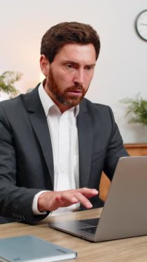 Merkez ofisteki orta yaşlı işadamı dizüstü bilgisayarın gözleri dondurmasını izliyor ve yeniden başlatmadan önce işten tasarruf etmek için tuşlara basıyor. Masadaki serbest çalışan eleman veri kaybı ve yedek plan için sistemi yeniden başlatıyor..