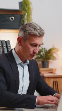 Genç işadamı ofis projesini bitirdikten sonra bilgisayarını kapatıp masa başında oturuyor. Kafkasyalı serbest çalışan, modern ofiste uzaktan kumandalı iş yapıyor. Netbook bilgisayarında gezinme, E-öğrenme İnternet.