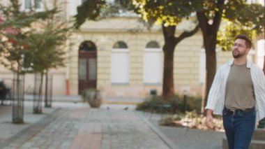 Erkek, sinirli, üzgün, üzgün, açık havada oturan beyaz bir adam, gece geç saatlerde akıllı telefondan telefon açıp birilerini ararken rahatsız oluyor. Şehirde kaybolan bir turist.