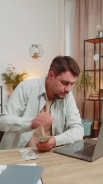 Planlama bütçesi. Zengin, mutlu bir adam, evdeki faturaları hesaplayarak para sayıyor. Beyaz adam gelir gelirinden memnun, planlı tatil hediyeleri için para. Dikey.