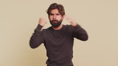 Ciddi bir Hindu öfkeli genç adamın portresi dövüş hareketi göstererek avucuna yumruk atıyor. Uzun kollu sakallı Lübnanlı adam rakibine saldırmaya hazır. Hintli İspanyol çocuk bej arka planda tek başına
