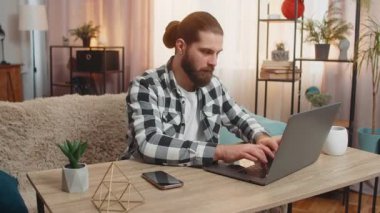 Genç adam evinde dizüstü bilgisayarı açıyor, klavyeye tıklıyor, birden sevinçle haykırıyor, harika bir galibiyet çevrimiçi kursta, önemli bilgiler ya da tavsiyeler buluyor, başarıyı kutluyor