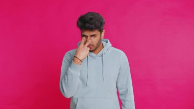 Gözüm üzerinde. Gözlerine ve kamerasına bakan özgüvenli adam, seni birini gözetlerken izlediğimi göster. Yakışıklı, hayal kırıklığına uğramış Hintli adam pembe stüdyo arka planında izole edilmiş.