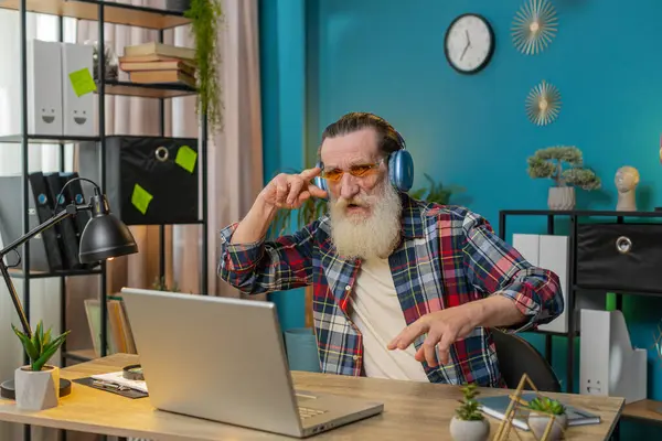 Son sınıftaki mutlu adam ofis masasında oturup kablosuz kulaklıkla en sevilen enerjik disko müziğini dinliyor. Heyecanlı serbest çalışan büyükbaba rahatlıyor, masadaki dizüstü bilgisayarla mola veriyor.