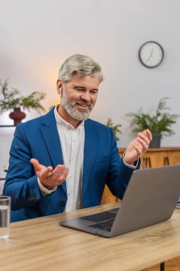 Merkez ofiste kulaklık takan orta yaşlı bir işadamı çağrı merkezi oturumunda gülümseyen bir çağrı hattına cevap veriyor. Masadaki serbest çalışan adam müşteri memnuniyetini arttırmak için kısa tavsiyeler veriyor..