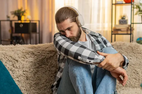 Genç adam evde oturup kulaklık takıyor, duygusal melodiler dinliyor, göz yaşlarına karşı savaşıyor. Kanepedeki adam kulaklıkları çıkarıp acı dolu ayrılık ya da ayrılık üzerine derin bir iç çekiş veriyor. Kırık kalp