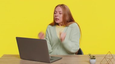 Mutlu Kafkasyalı orta yaşlı iş kadını dizüstü bilgisayar üzerinde çalışıyor zaferin şokunu kutluyor gol başarısını kutluyor, iyi e-posta kariyeri haberleri sarı arka planda yalnız başına oturuyor.