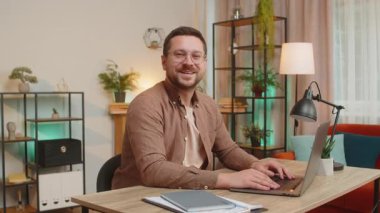 Hoş geldiniz. Kafkas 'lı mutlu iş adamı el sallayarak selam veriyor. Birine hoş geldin diyor. İnternetteki Webinar, uzaktan konuşma. Ofisteki bilgisayarla masa başında oturan serbest çalışan bir adam..