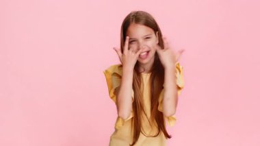 Genç kız neşeyle dans eder ve hareketli bir şekilde el kaldırarak rock 'n' roll yapar. Enerjik ve kendinden emin bir ruh hali içindedir. Pembe arka plandaki okul çocuğu, performans sırasında kendini havalı hissediyor.