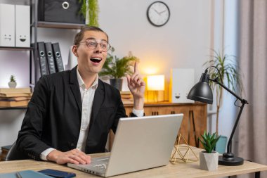 Gülümseyen beyaz bir adam dizüstü bilgisayarda iyi bir fikir bulmayı düşünüyor. Profesyonel iş adamı masadaki evden önemli e-postalar yazıyor. Çevrimiçi uzaktan kumanda işinde çalışan mutlu adam.