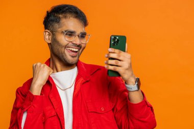 Mutlu Hintli genç adam akıllı telefon daktilo kullanıyor ve bağırıyor 