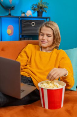 Beyaz çocuk evde dizüstü bilgisayardan film izlemekten hoşlanıyor. Patlamış mısır çiğner, komik sahnelerde güler, kanepede rahat bir şekilde yatarken karnına sarılır, oturma odasında eğlenir.