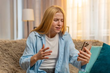 Genç bir kadın elinde akıllı telefonuyla evde oturur, kötü haberleri keşfeder ve şok, üzüntü ve pişmanlık hisseder. Kafkasyalı kız kanepeye yığıldı, gün batımında yenilgiden sonra umutsuzluğa düştü.