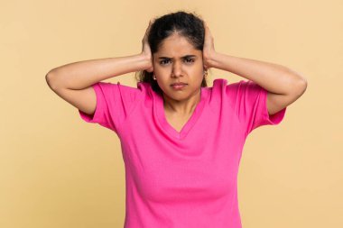 Hintli bir kadın kulaklarını hızla elleriyle kapatır, şiddetle kaşlarını çatar, gürültüden rahatsız olur. Arap kız rahatsız edici, dinlemeye isteksiz, rahatsız edici sesler çıkarıyor..