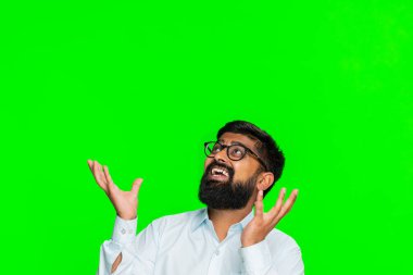 Hintli adam kollarını yukarı kaldırır ve havada süzülen sancağa, yazıya ya da logoya uzanır, yukarıdaki boşluğu gösterir. Arap adam yeşil renkli anahtar arka plan reklamında izole edilmiş ya da sanal içeriği destekliyor