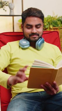 Hintli adam ilginç kitaplar okuyor, sayfaları çevirip gülümsüyor edebiyattan zevk alıyor, rahat koltukta dinleniyor. Huzurlu, neşeli bir adamın portresi. Oturma odasında dinleniyor. Sandalyede.