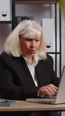 Öfkeli, öfkeli, yaşlı, serbest çalışan iş kadını ofis bilgisayarını kullanıyor, iş yerinde sinir krizi geçiriyor, stres yönetimi, zihinsel stres sorunları, kendini kaybetmek, başarısızlığa tepki vermek....