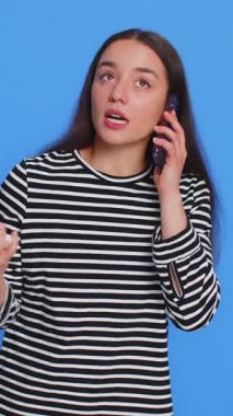 Sinirli, gergin, beyaz bir kadının iki cep telefonuyla bağırarak konuşma yapması anlaşmazlık şikâyeti tartışması sorunu çözer. Mavi arka planda izole edilmiş genç kız