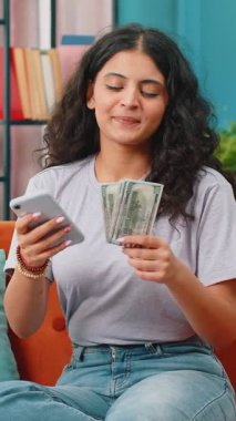 Planlama bütçesi. Zengin mutlu Hintli kadın akıllı telefon hesap makinesi kullanıyor. Para sayıyor, ev faturalarını hesaplıyor. Kazancından memnun bir kız tatil hediyeleri için para biriktirir.