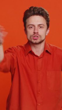 Tartışma. Sinir bozucu ve hoşnutsuzca el kol hareketi yapan agresif, mutsuz, Kafkasyalı bir adam başarısızlıktan dolayı azarlıyor, bunun neden olduğunu soruyor. Genç adam turuncu arka planda izole