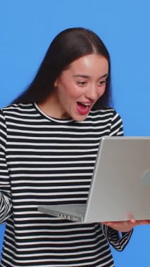 Mutlu beyaz kadın dizüstü bilgisayarda yazı yazıyor, proje üzerinde çalışıyor, sonuçların tadını çıkarıyor, başarıyı kutlayan piyango oyununu kazanıyor, online alışveriş zaferi iyi e-posta haberleri. Mavi arka planda güzel bir kız