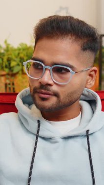 Mutlu, sakin Hintli bir adamın portresi. Dostça gülümsüyor, mutlu bir yüz ifadesi başka tarafa bakıyor. Hayal kuruyor, rahatlıyor. Arap genç adam oturma odasında.