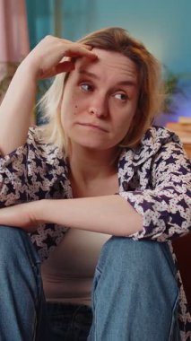 Üzgün, yalnız, beyaz kadın, hayat endişeleri yüzünden dalgın görünüyor. Kanepede oturan adaletsiz bir durumdan muzdarip. Eli saçı olan üzgün bir kız evdeki oturma odasında kendini kötü hissediyor..