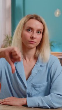 Hoşlanmamak. Kafkasyalı genç iş kadını, hoşnutsuzluğunu, hoşnutsuzluğunu, tatminsizliğini ve kötü çalışmalarını ifade ederek işaret ediyor. Memnuniyetsiz serbest çalışan kız çalışma odasında masa başında..