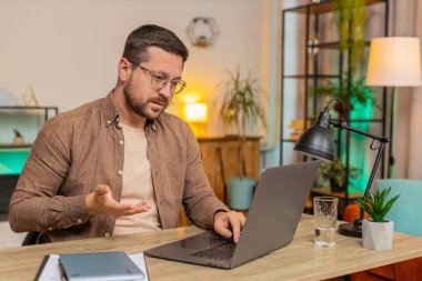 Ev ofisinin bilgisayarında çalışan mutlu iş adamı çalışanlarıyla online haberleşme videosu konuşması yapıyor, patron. Yönetici adam bilgisayarın webcam 'ine el sallayarak bakan servisleri destekler.