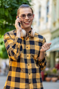 Kafkasyalı turist arkadaşlarıyla uzaktan iletişim kuruyor, telefonla konuşuyor şehir caddesinde beklenmedik iyi haber dedikoduları yapıyor. Şehir yaşam tarzları açık havada.