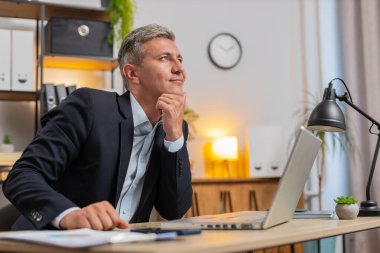 Genç girişimci, sunum için başlangıç projesini hazırlıyor ve fikri buluyor. Çalışan serbest çalışan, ofis masasında dizüstü bilgisayarla otururken düşünüyor. Uzak çalışma.