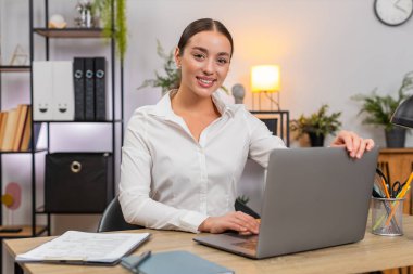 Merkez ofisteki genç mutlu iş kadını dizüstü bilgisayarı açar ve bugün işe başlamak için daktilo yazmaya başlar. Masadaki serbest çalışan kız liste yapmak için plan kontrolleri yazar ve müşteri için rapor hazırlar.